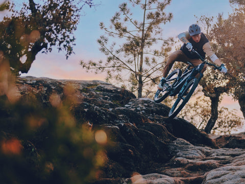 Jasper Jauche dropping into a rock slab on a bike running Sidekick hubs.