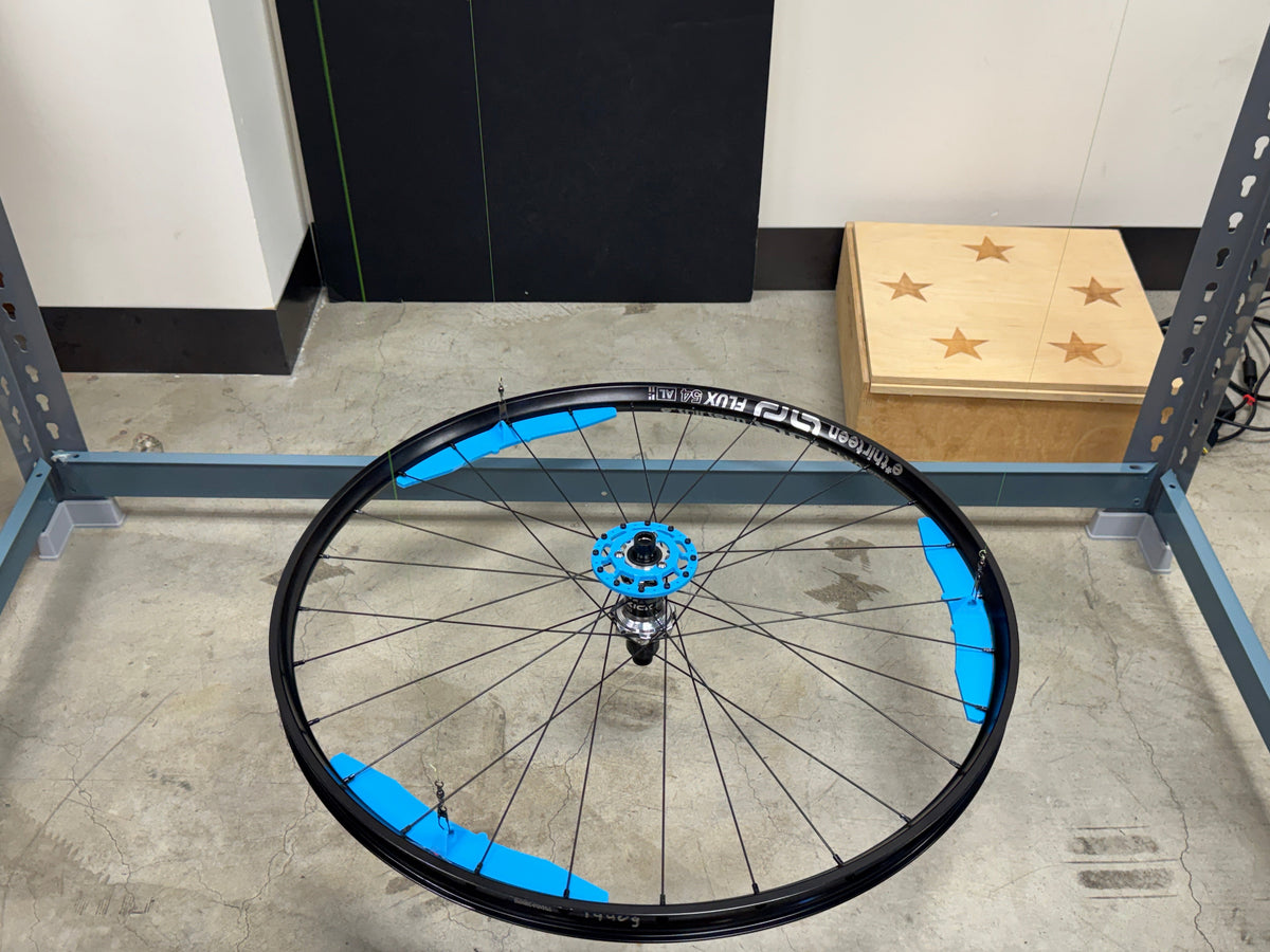 A built Sidekick Flux wheel standing in the test frame.