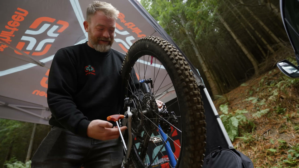 An e*thirteen mechanic working on a rider's bike under the tent.