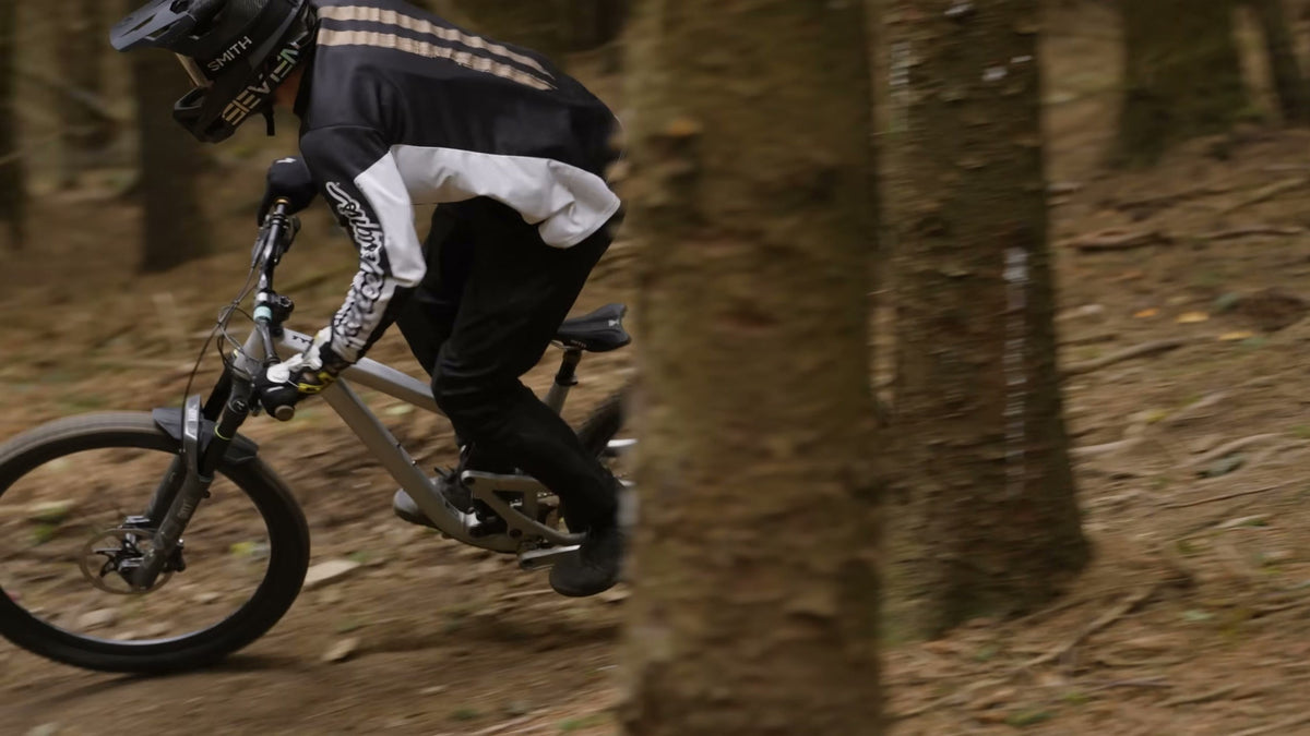 A rider railing a loamy corner through the pines at Redwood Park.