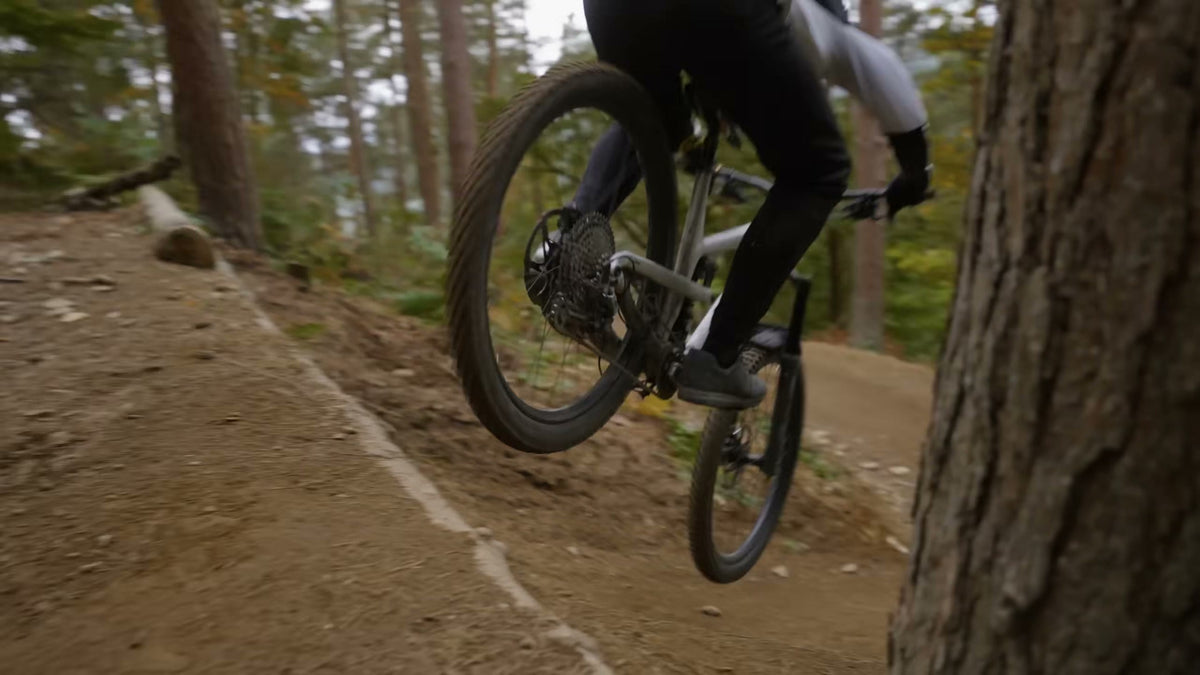 A rider jumping a trail lip at Redwood Park on Sidekick wheels.