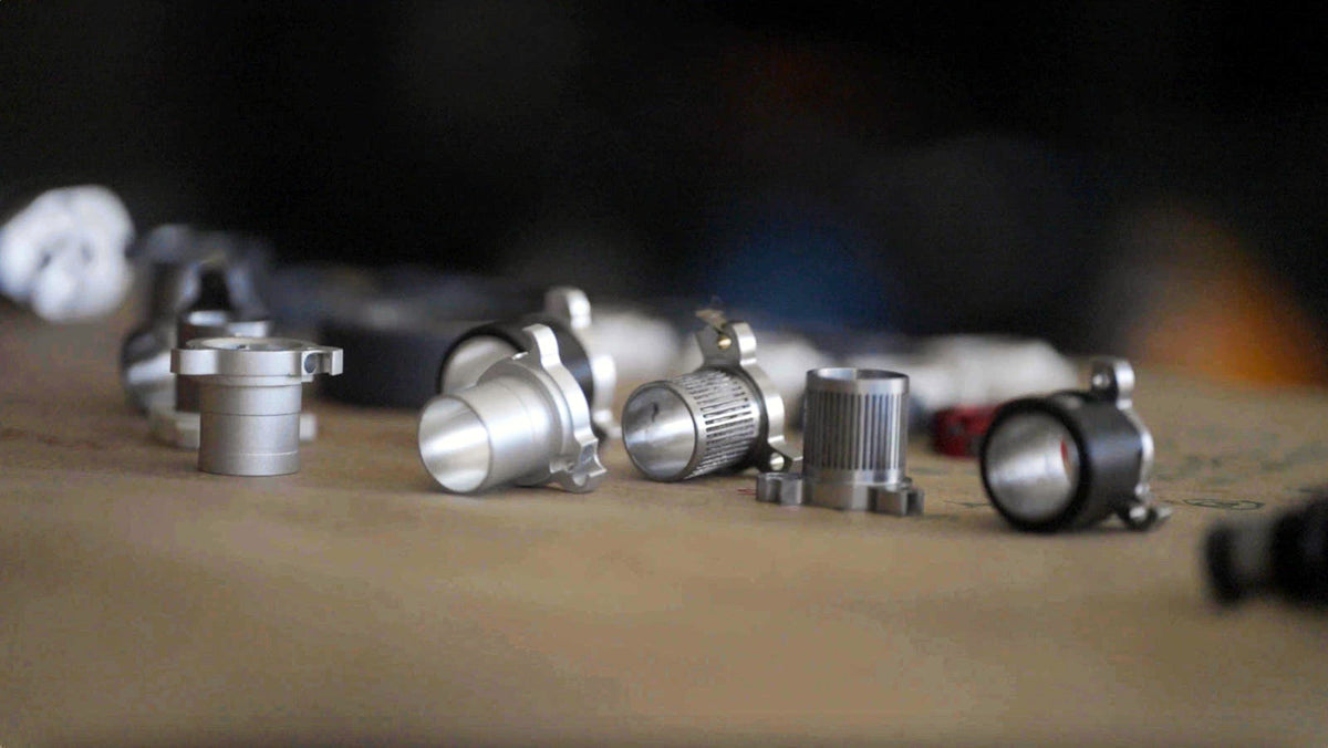 A row of machined aluminum Sidekick hub prototypes on a workbench